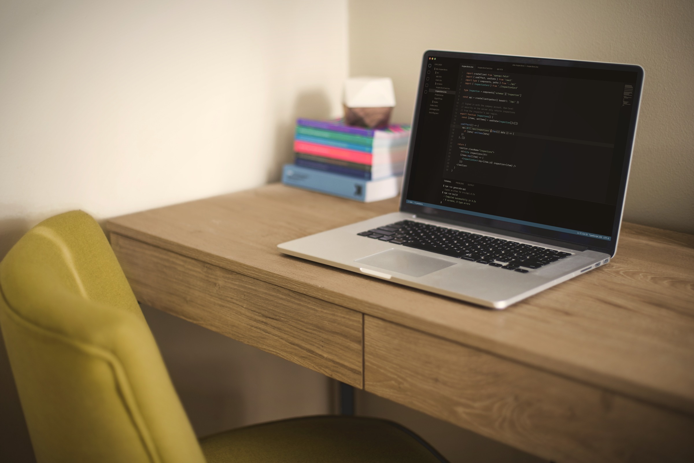 A laptop on a wooden desk, showing the code behind a working app