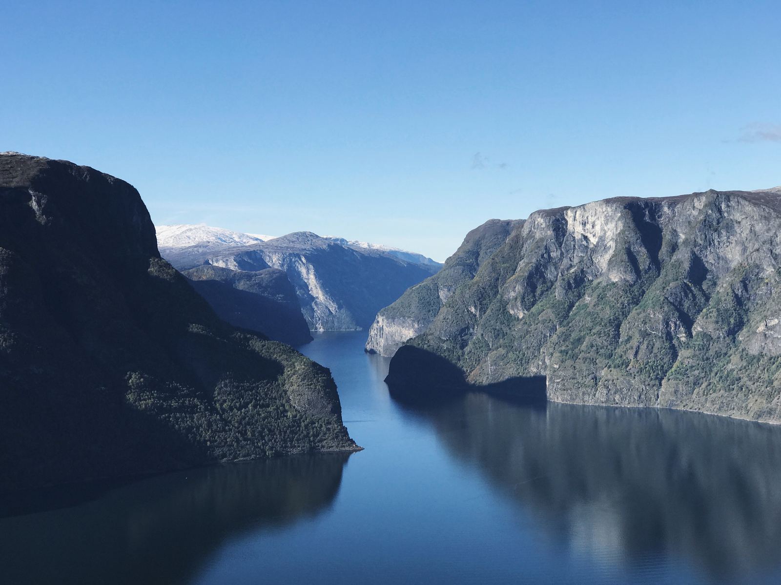 A Norwegian fjord between steep mountainsides on a clear day